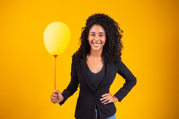 Jovem mulher afro segurando um balão com espaço livre para texto.