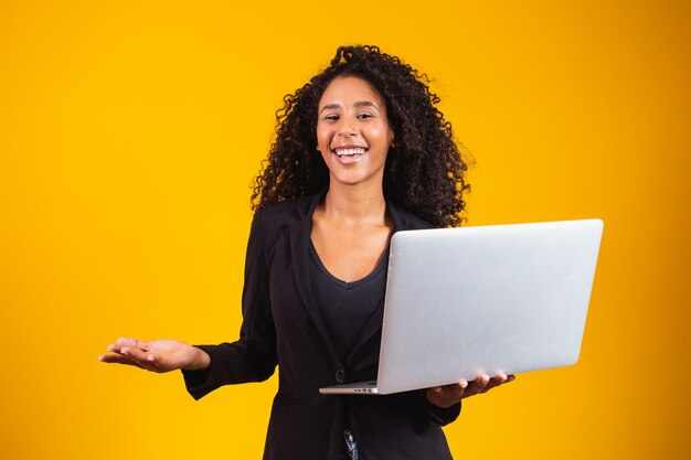 Foto jovem mulher afro usando laptop