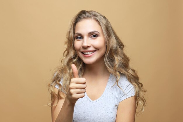 Jovem mulher alegre feliz aparecendo o polegar.