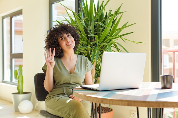 Jovem mulher árabe bonita com um laptop sobre uma mesa