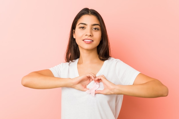 Jovem mulher árabe com laço rosa. de luta contra o câncer.