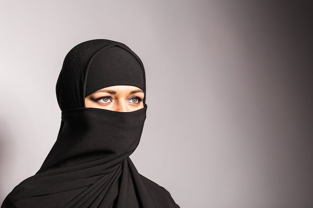 Jovem mulher árabe em hijab ou niqab.