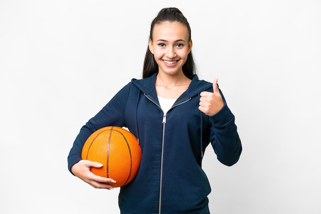 Jovem mulher árabe sobre fundo branco isolado, jogando basquete e com o polegar para cima