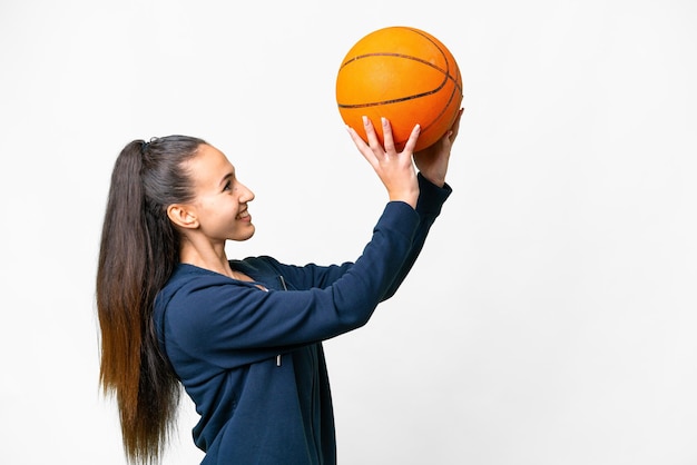 Jovem mulher árabe sobre fundo branco isolado, jogando basquete