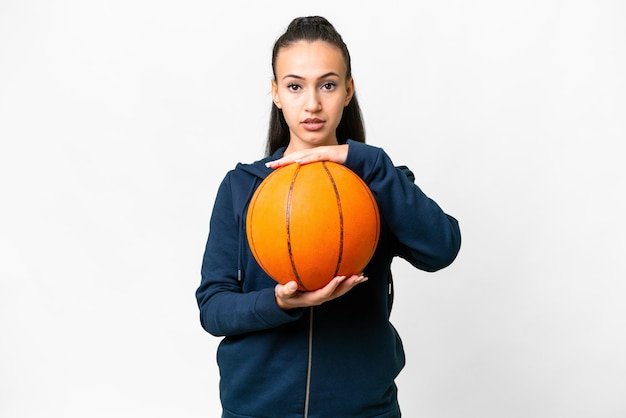 Jovem mulher árabe sobre fundo branco isolado, jogando basquete