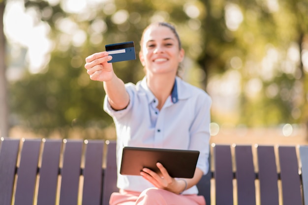 Jovem mulher às compras on-line no parque