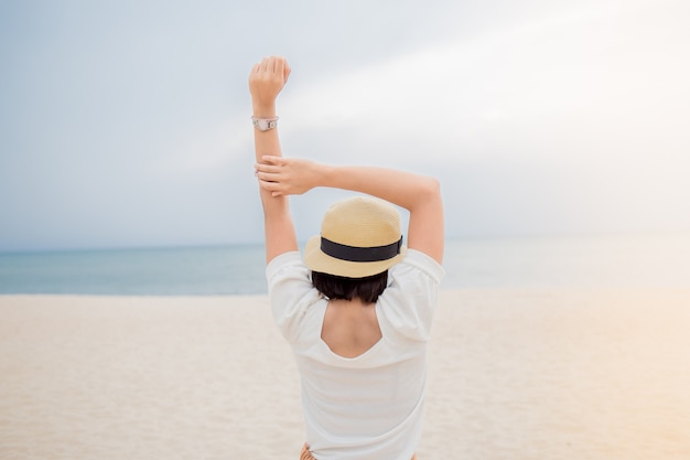 Jovem, mulher asian, relaxante, ligado, praia, vista oceano, férias, ao ar livre, seascape, conceito