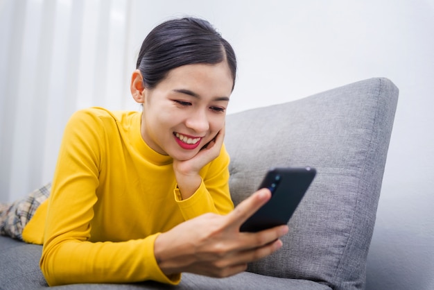 Jovem mulher asiática assistindo algo no celular