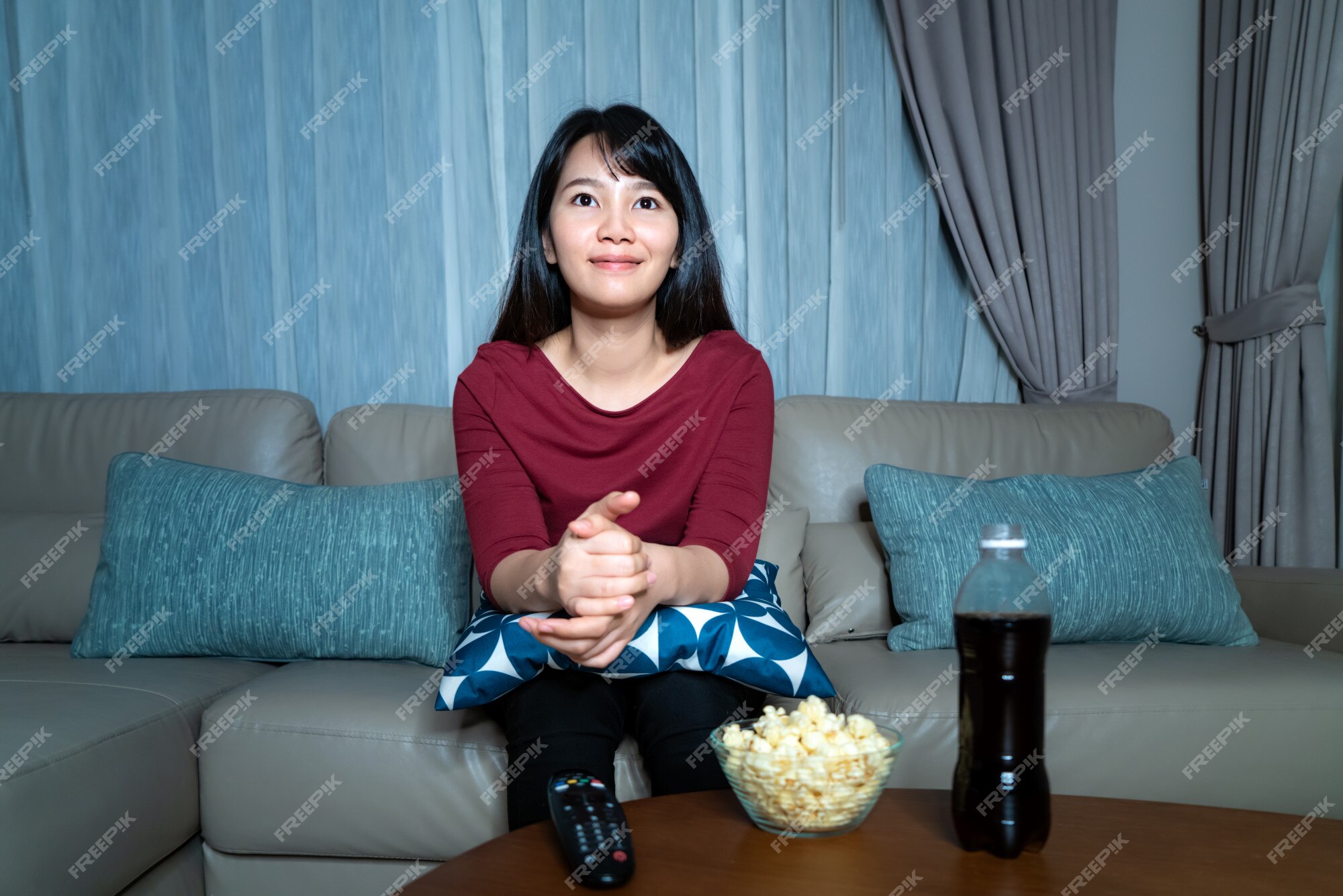 Garota feliz com telefone relaxa no sofá ou no sofá da sala