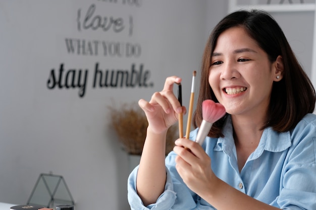 Jovem mulher asiática beleza blogger mostrando como fazer vídeo tutorial de gravação por câmera