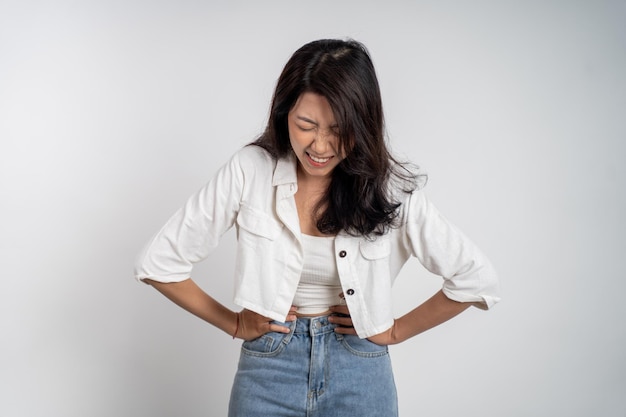 Foto jovem mulher asiática com dor com as duas mãos segurando o estômago