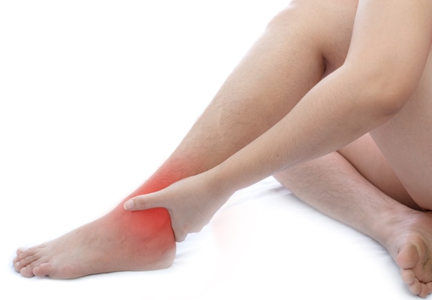 Jovem mulher asiática com dor no tornozelo em fundo branco Conceito de desconforto de problema de saúde