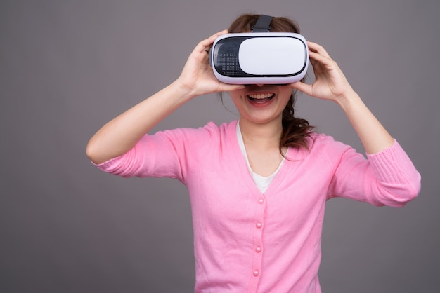 Jovem mulher asiática com óculos de realidade virtual