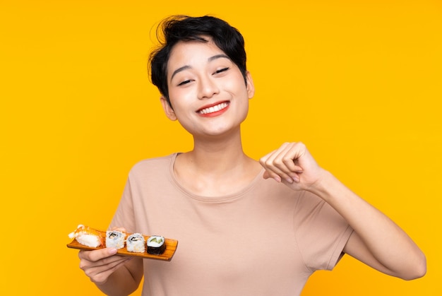 Jovem mulher asiática com sushi orgulhoso e satisfeito