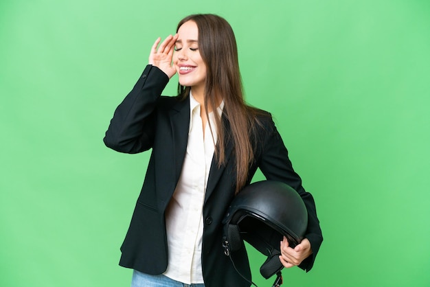 Jovem mulher asiática com um capacete de motocicleta sobre fundo croma isolado sorrindo muito