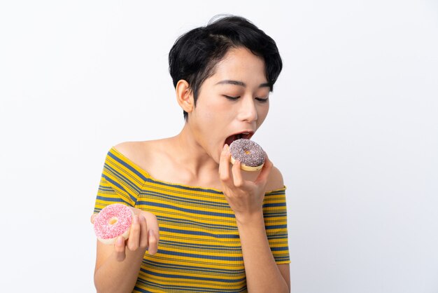 Jovem mulher asiática comendo uma rosquinha