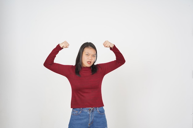 Foto jovem mulher asiática de camisa vermelha mostrando braços fortes emancipação do conceito de mulheres isolado em fundo branco