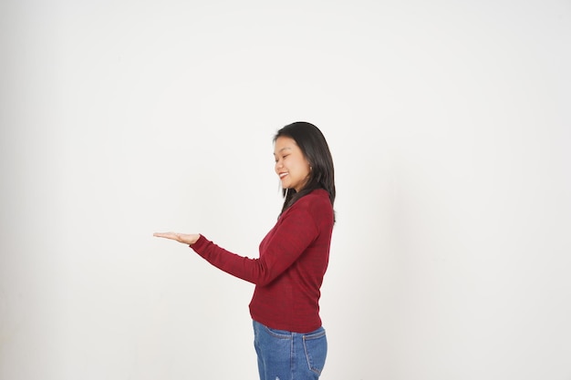 Jovem mulher asiática de camisa vermelha mostrando e segurando um espaço de cópia de palma aberta isolado em fundo branco