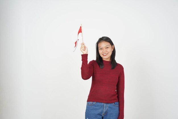 Foto jovem mulher asiática de camisa vermelha segurando a bandeira indonésia conceito de dia da independência isolado em fundo branco