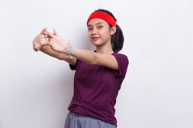 Jovem mulher asiática esportiva fazendo alongamento em fundo branco