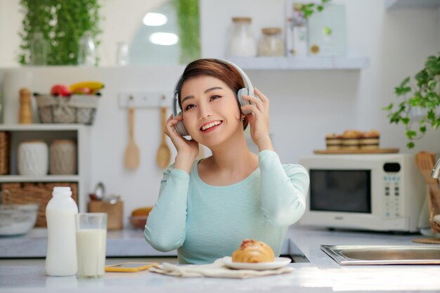 Jovem mulher asiática gosta de ouvir música com fones de ouvido e relaxar.