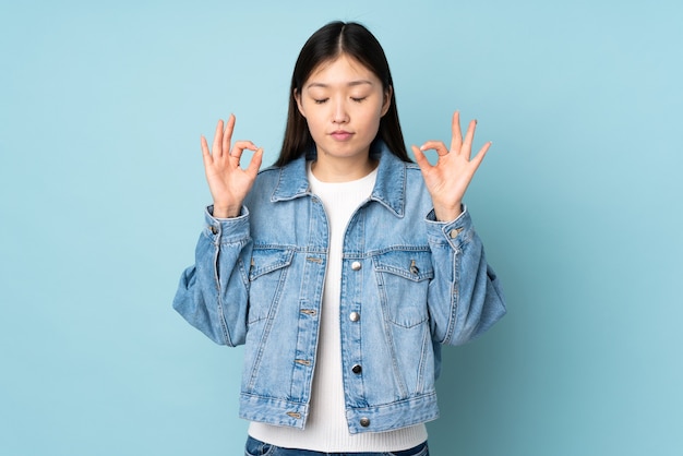 Jovem mulher asiática isolada em pose zen