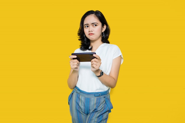 Jovem mulher asiática jogando jogos no smartphone