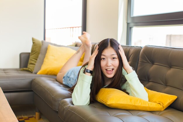 Jovem mulher asiática parecendo feliz, despreocupada, amigável e relaxada curtindo a vida e o sucesso, com uma atitude positiva