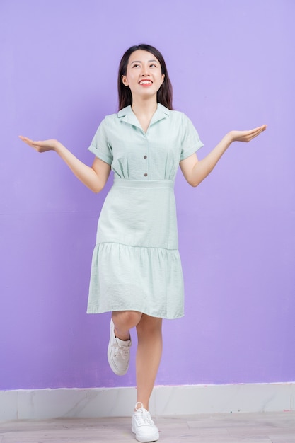 Jovem mulher asiática posando em fundo roxo