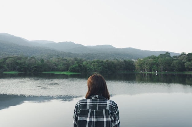 Jovem mulher asiática que está de cara o mar. sentindo-se realmente solitário, de coração partido