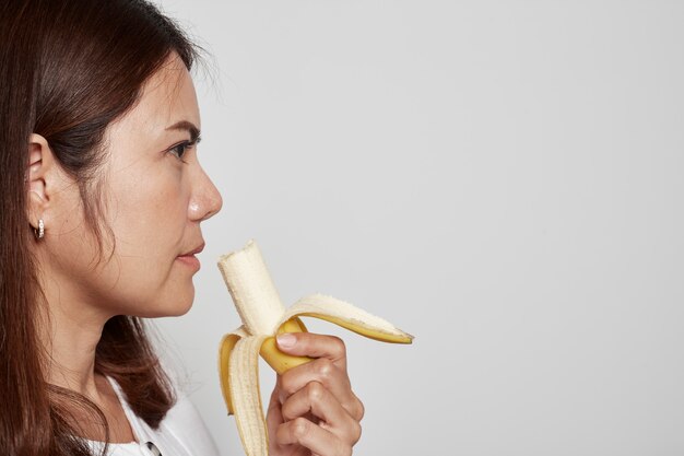 Jovem mulher asiática segurando banana