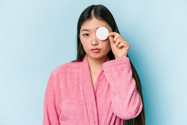 Jovem mulher asiática segurando um disco facial isolado no fundo rosa