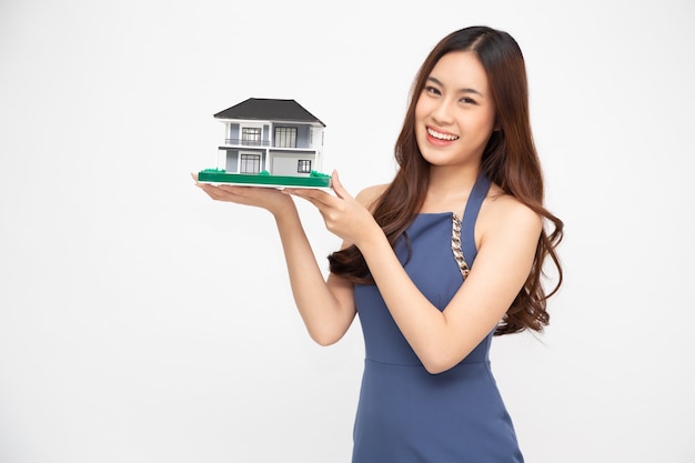 Jovem mulher asiática segurando um modelo de casa
