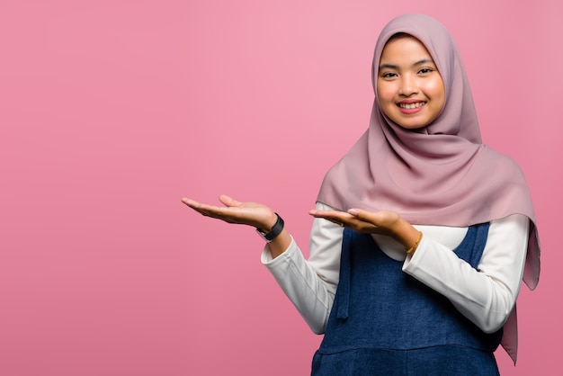 Jovem mulher asiática sorrindo e mostrando produtos