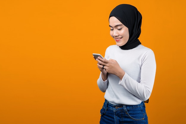 Jovem mulher asiática sorrindo e usando o celular