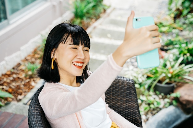 Jovem mulher asiática tomando uma selfie