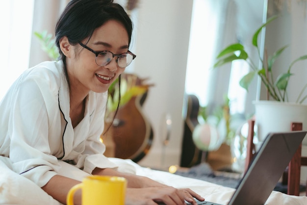 Jovem mulher asiática trabalhando freelance trabalhando em laptop em casa trabalhando em casa conceito