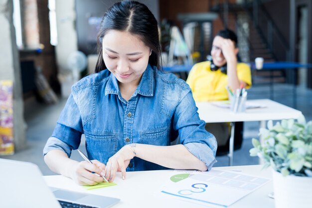 Jovem mulher asiática trabalhando no escritório moderno