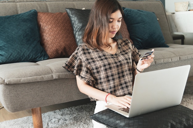 Foto jovem mulher asiática usando cartão de crédito para fazer compras online