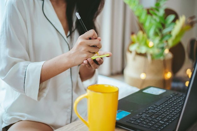 Jovem mulher asiática usando laptop para trabalhar online, mulher freelance trabalhando em casa usando tecnologia de comunicação do ciberespaço da internet para trabalho de mulher de negócios