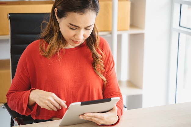 Jovem mulher asiática usando tablet em casa