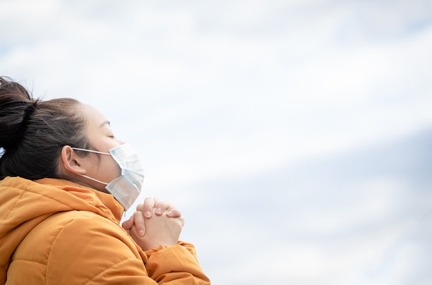 jovem mulher asiática usando uma máscara para evitar germes, fumaça tóxica e poeira
