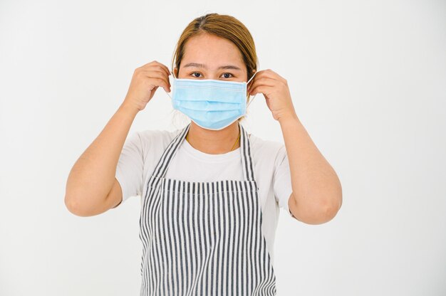 Jovem mulher asiática usando uma máscara protetora para impedir a propagação do conceito de germes e vírus