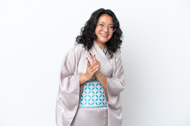 Jovem mulher asiática vestindo quimono isolado no fundo branco aplaudindo após apresentação em conferência