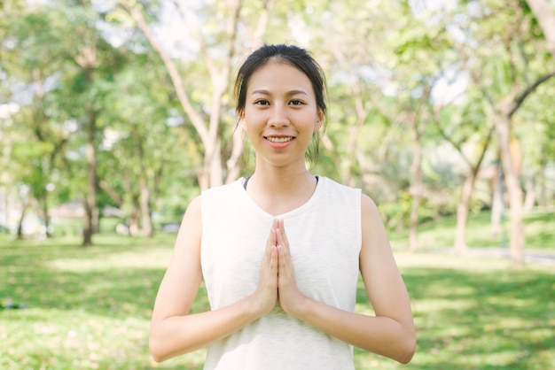 Jovem, mulher asiática, yoga ao ar livre mantenha a calma e medita durante a prática de ioga