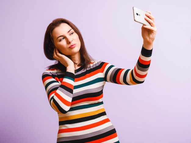 Jovem mulher atraente faz selfie.