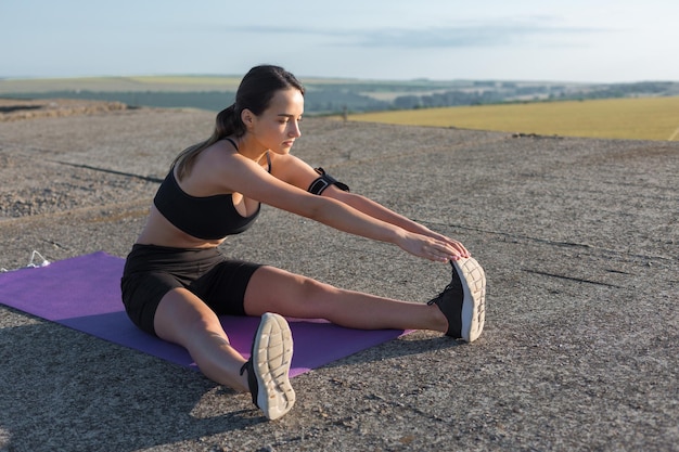 Foto jovem mulher atraente fazendo exercícios malhando ao ar livre.