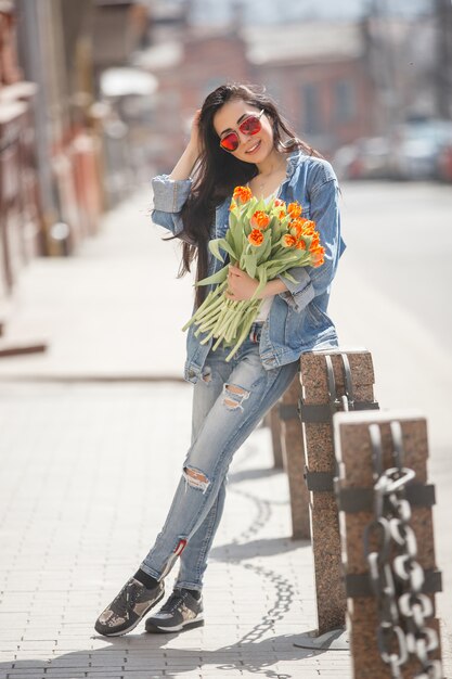 Jovem mulher atraente segurando flores ao ar livre