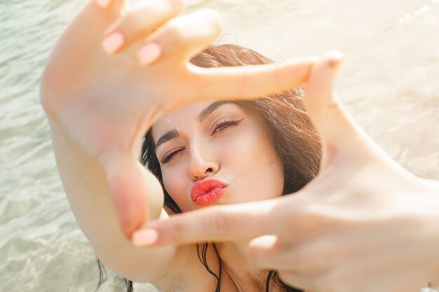 Jovem mulher atraente tirando uma selfie na praia