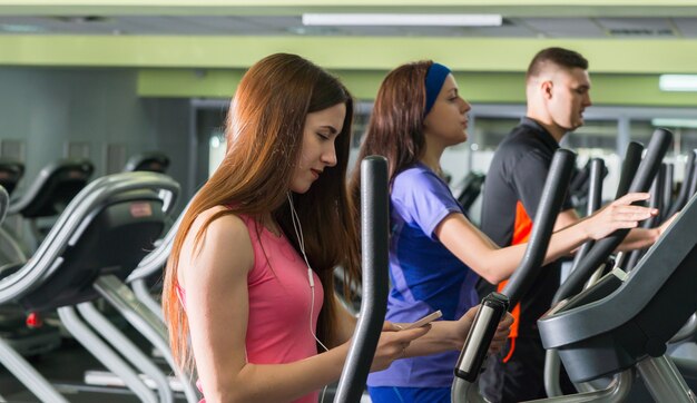 Jovem mulher atraente tocando música enquanto se exercita